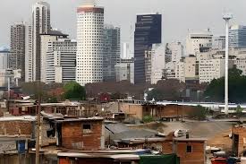 Ciudad con edificios modernos y casitas pobres.