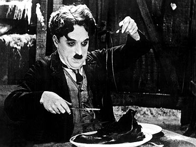Una famosa escena de «la quimera del oro» de Charles Chaplin», El protagonista desesperado de hambre1 procede a comerse su za